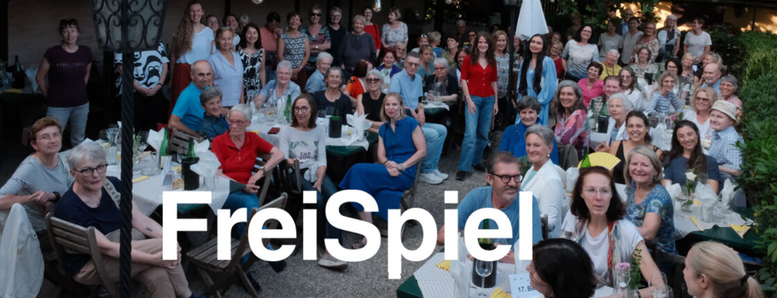 Freiwillige des Vereins FreiSpiel sitzen anlässlich des Sommerfestes in einem Hof und amüsieren sich