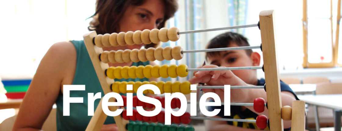 Freiwillige übt mit einem Kind Mathematik am Abakus im Klassenraum