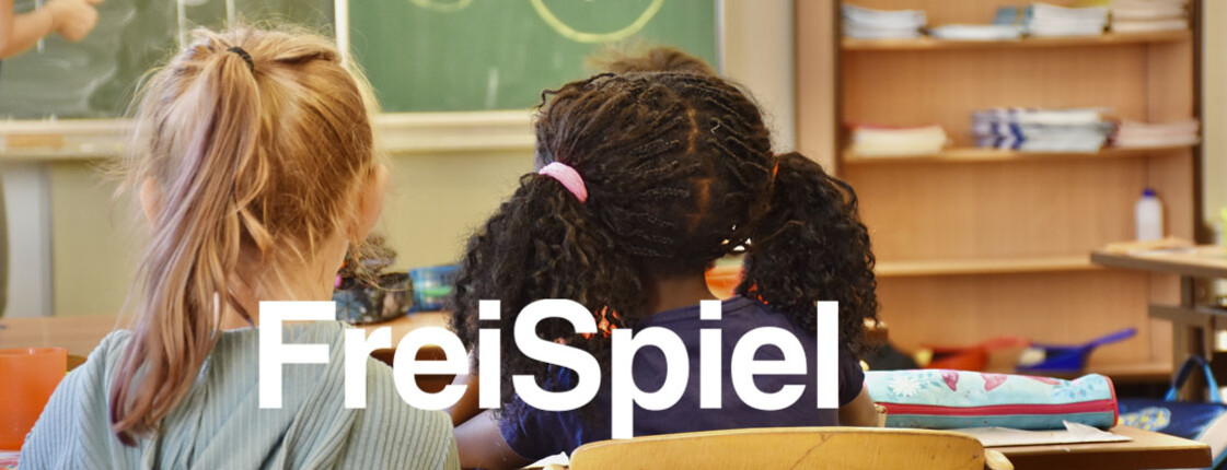 Zwei Schulkinder sitzen im Klassenzimmer und folgen dem Unterricht